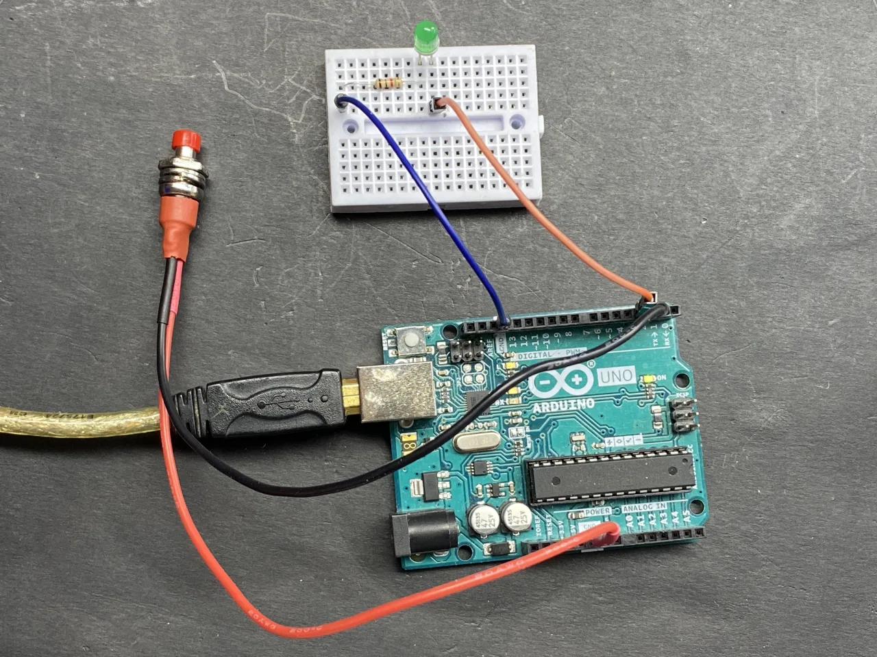 LED with resistor on breadboard connected to Arduino with a push button